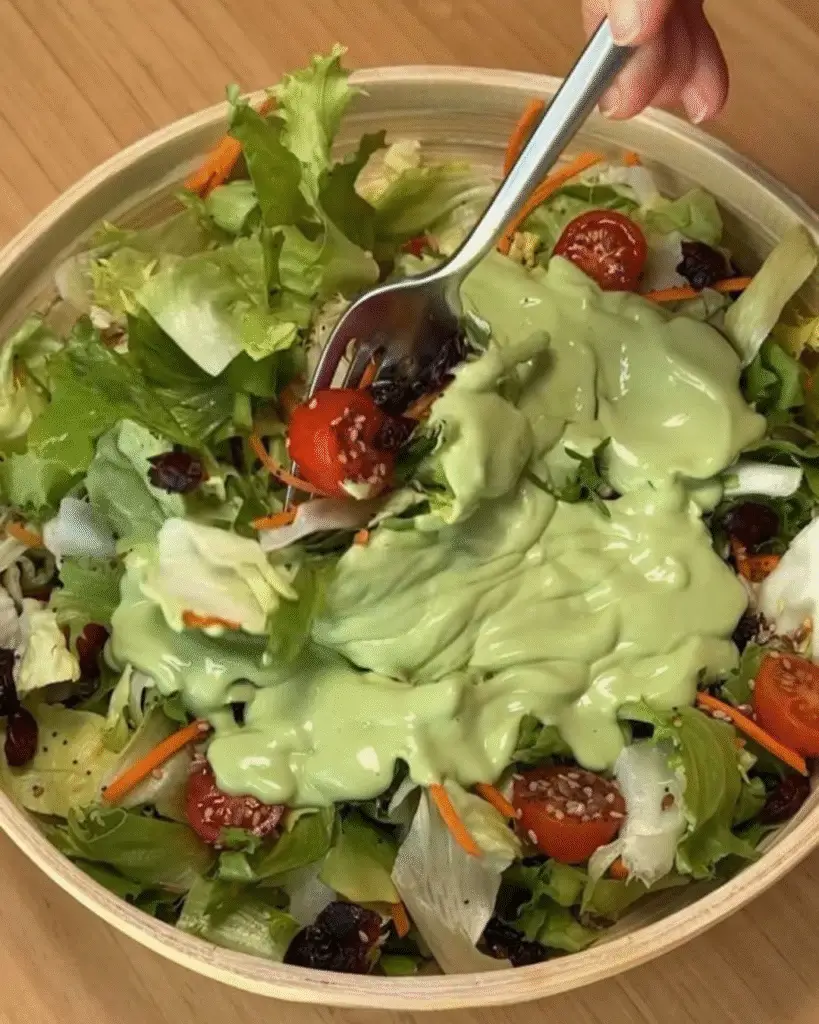 Aderezo verde cremoso sobre ensalada fresca con tomate cherry y zanahoria